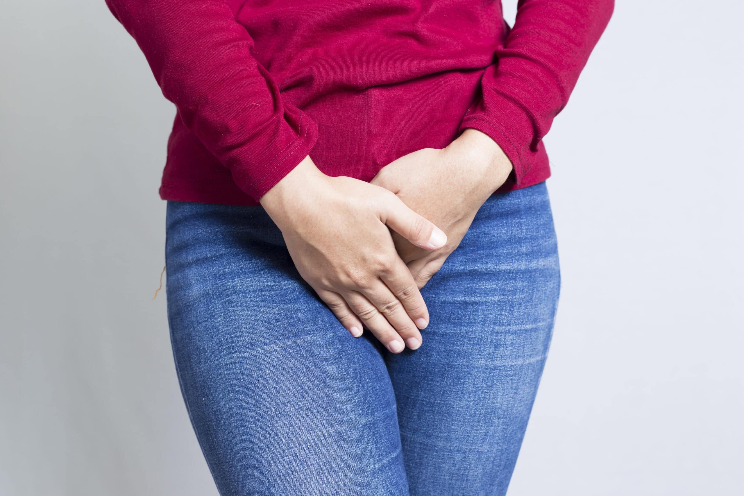 Woman,with,hands,holding,her,crotch,isolated,in,a,white